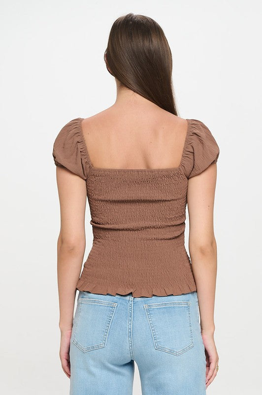 Woman wearing a top with a bow detail on a white background