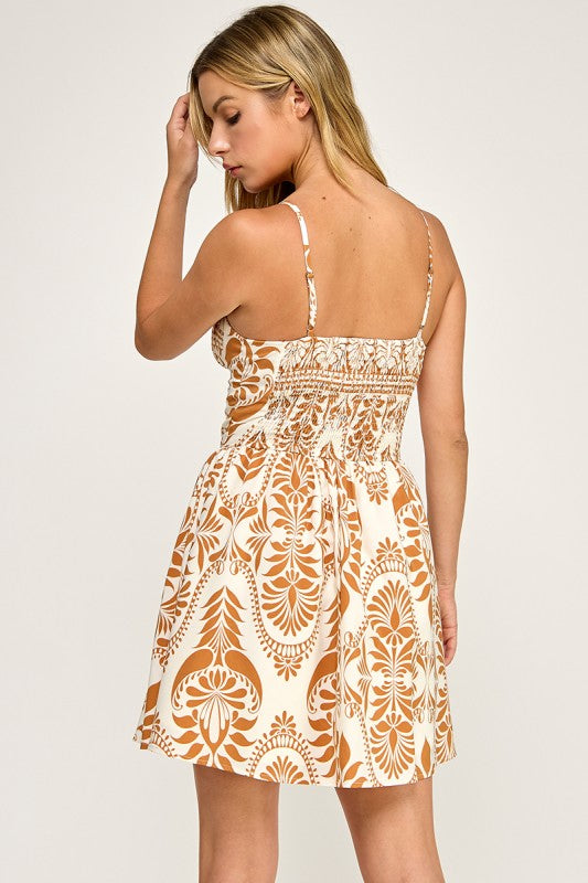 Woman wearing a patterned dress on a plain background