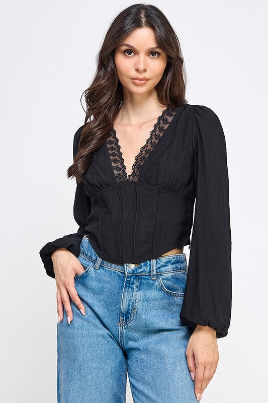 Woman wearing a blouse with long sleeves and white pants on a plain background
