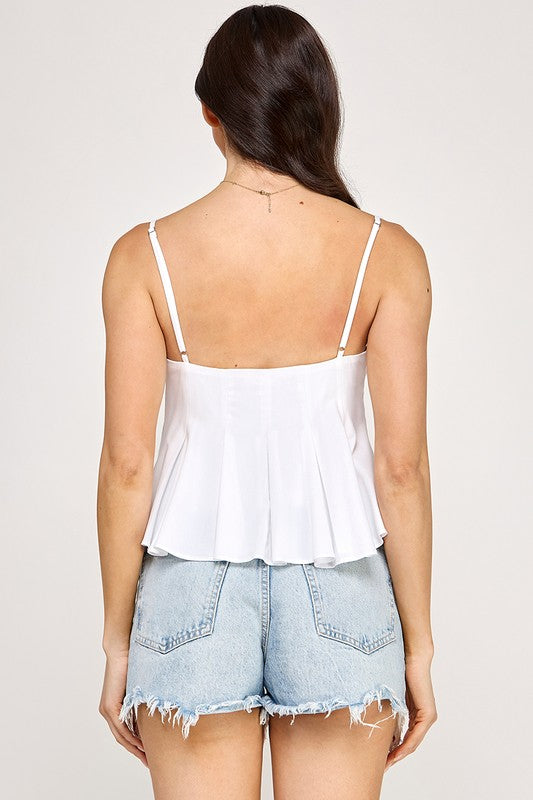 Woman wearing a peplum top and denim shorts on a plain background
