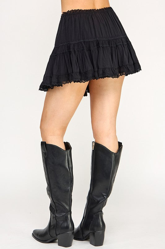 Woman wearing a white top and skirt with knee-high boots on a white background