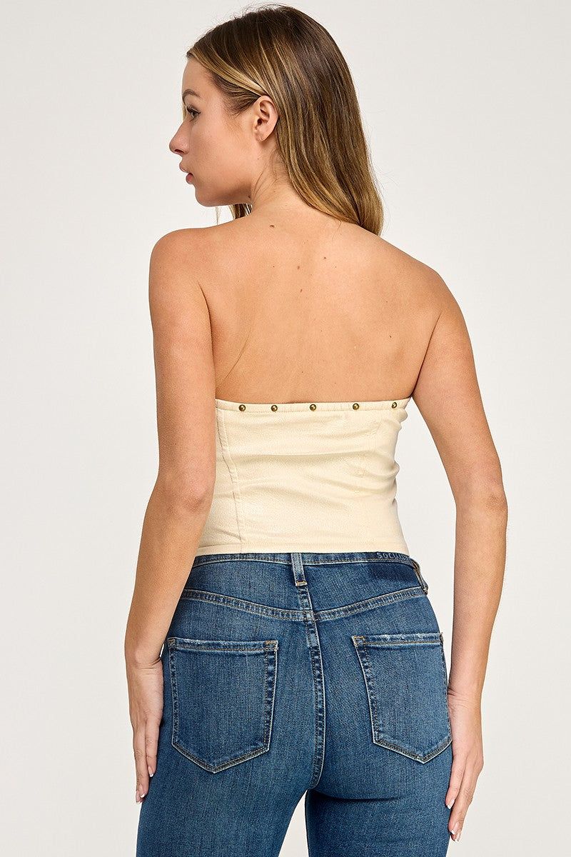 Woman wearing a black strapless top and blue jeans on a white background