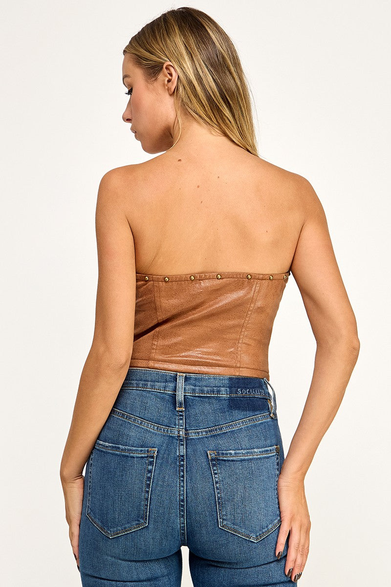 Woman wearing a black strapless top and blue jeans on a white background