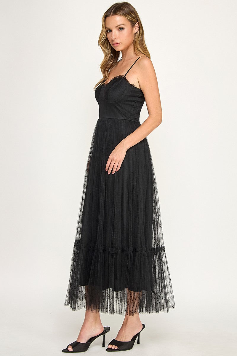 Woman wearing a dress with sheer overlay on a white background
