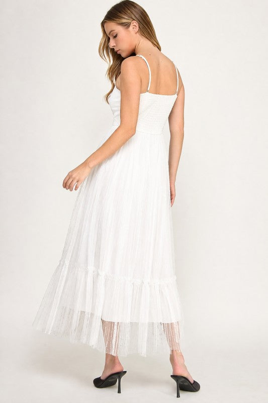 Woman wearing a dress with sheer overlay on a white background
