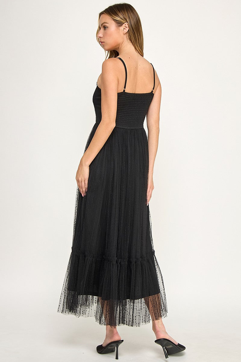 Woman wearing a dress with sheer overlay on a white background