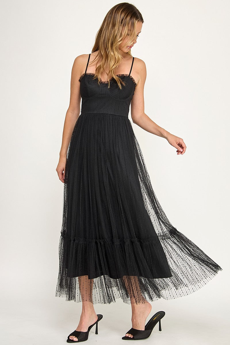 Woman wearing a dress with sheer overlay on a white background